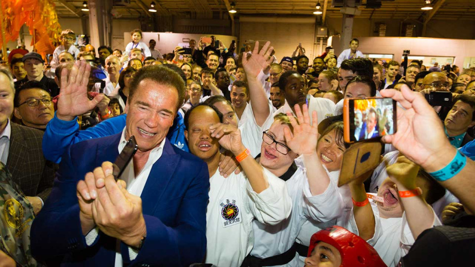 Arnold posing with a group of fans.